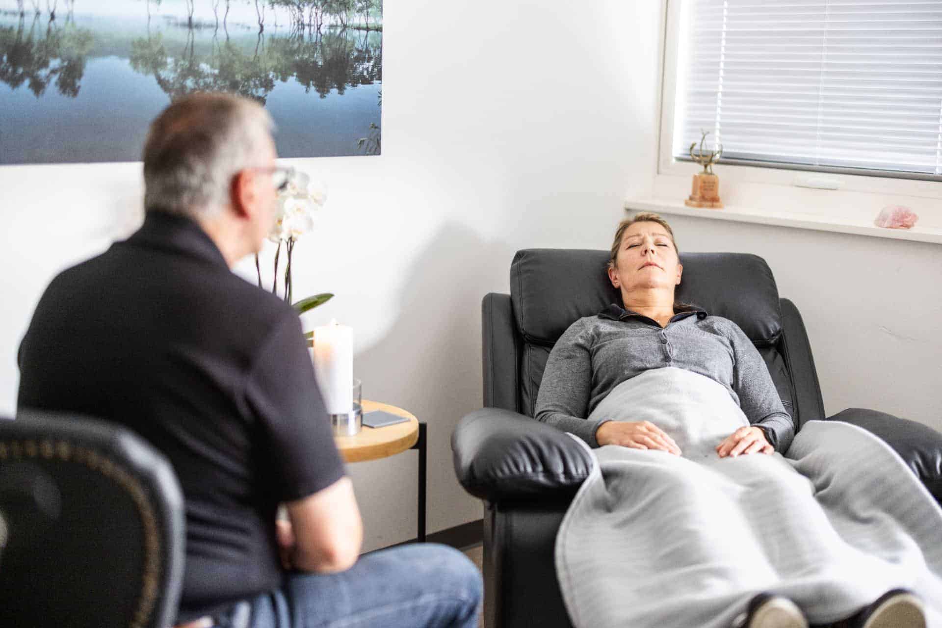 Kvinde slapper af i lænestol under session med hypnose mod stress hos Bisling Motivationsterapi.