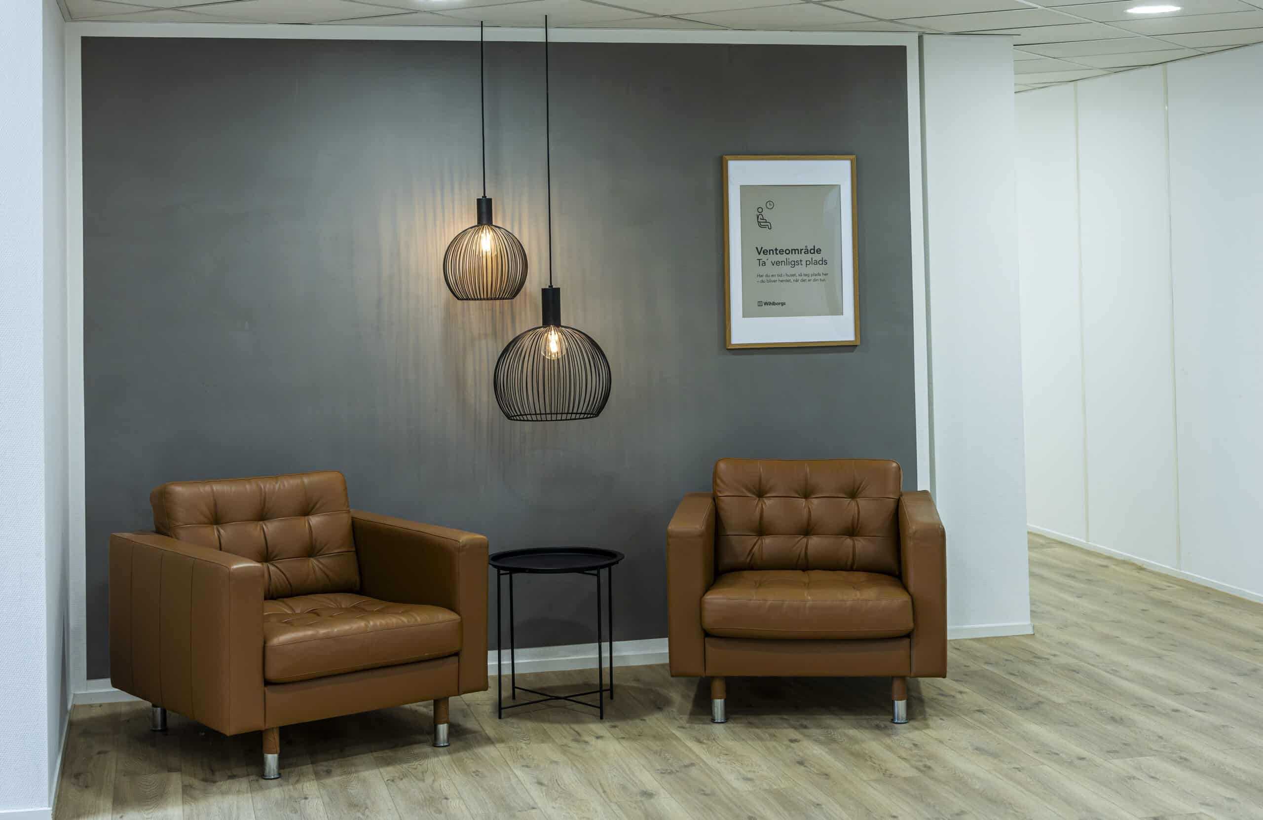 Komfortabelt venteområde med læderstole til klienter i klinik for hypnose stress